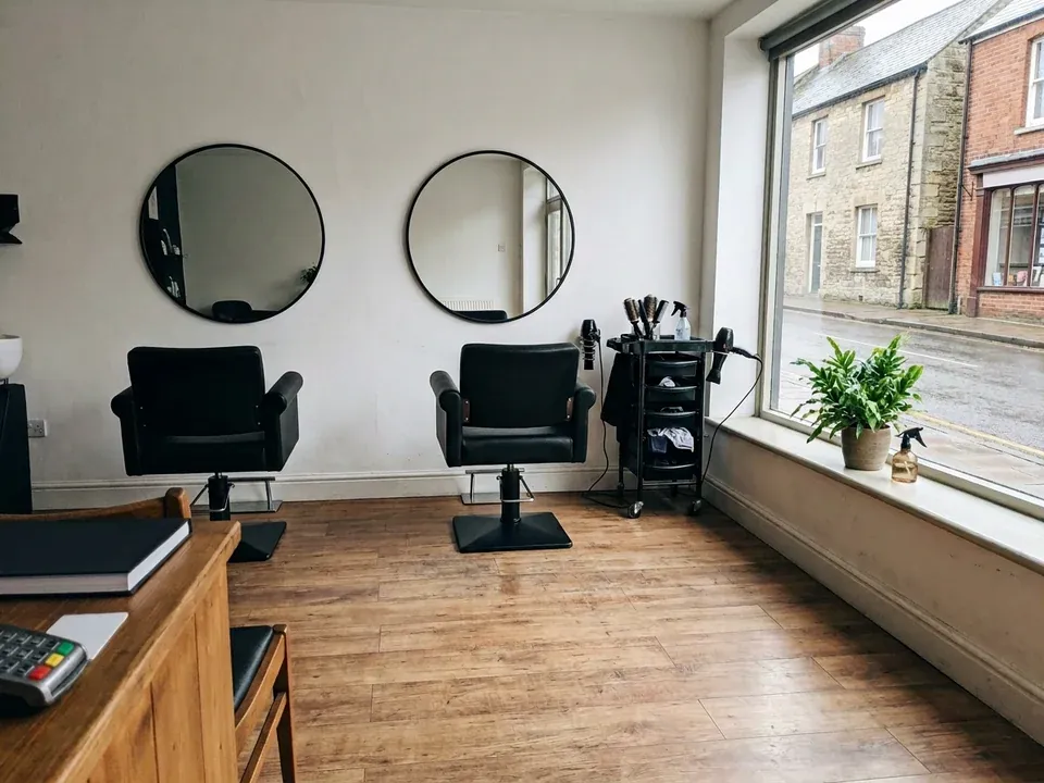 A small salon with two chairs and mirrors in daylight